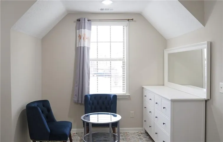 Angled ceilings and a classic multi-pane window bring architectural interest to this cozy upper-level space.