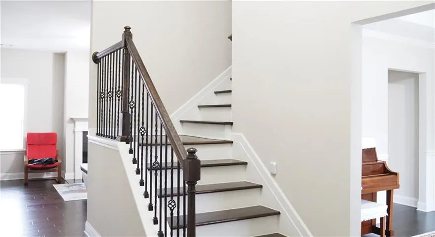 A graceful wooden staircase with wrought iron balusters serves as the home's central architectural focal point.