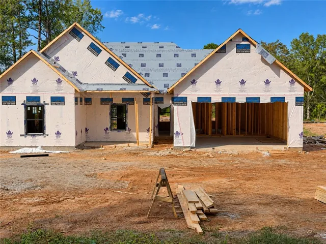 New residential construction showcasing a spacious multi-gable design under a clear blue sky.