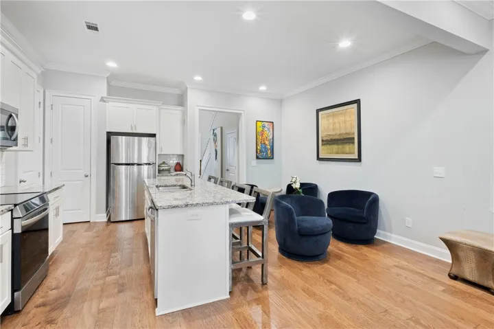 Gleaming wood floors run through an inviting open kitchen designed with a central island.