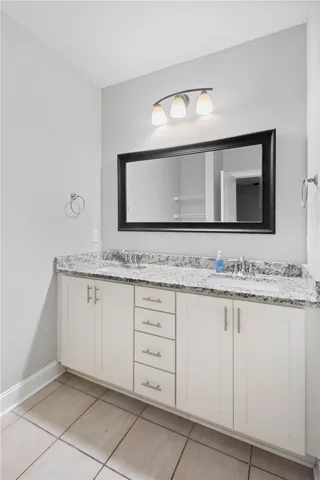 Double vanities with stone counters and modern fixtures enhance this updated bathroom space.
