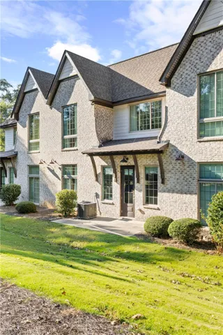 Timeless brick exterior detailing meets multiple gables and a concrete patio setting.