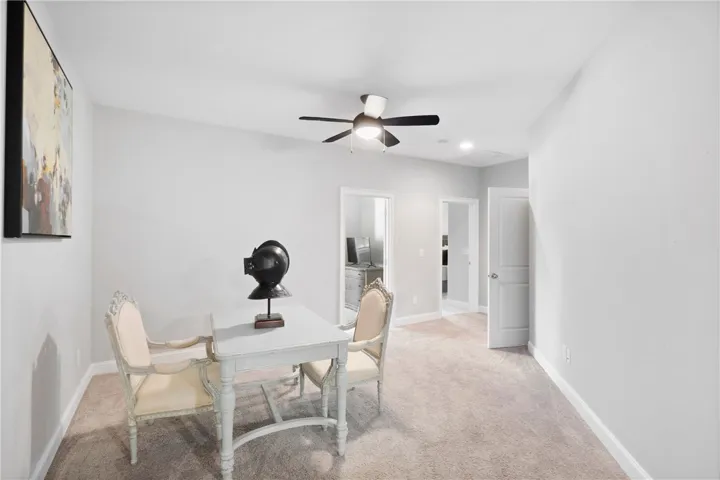 A versatile home office area features soft neutral carpeting and smooth plaster walls.