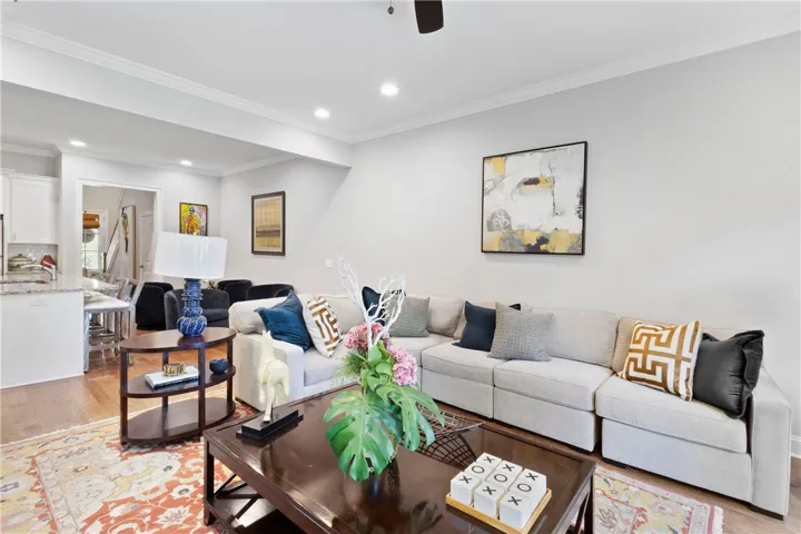 Polished crown molding and rich hardwood flooring ground this inviting, light-filled living area.