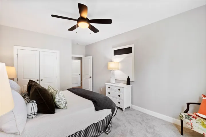 Soft plush carpeting paired with clean neutral walls anchors this inviting secondary bedroom.