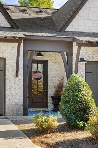 Whitewashed brickwork pairs with rustic timber accents to frame a welcoming covered front entryway.