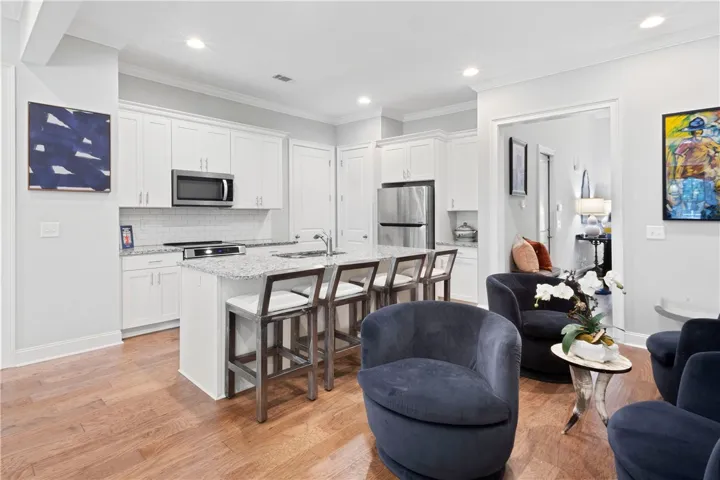 Gleaming hardwood floors and stone counters anchor this bright, open kitchen layout.