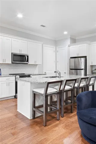 Gleaming hardwood floors and a spacious stone-topped island define this modern culinary workspace.