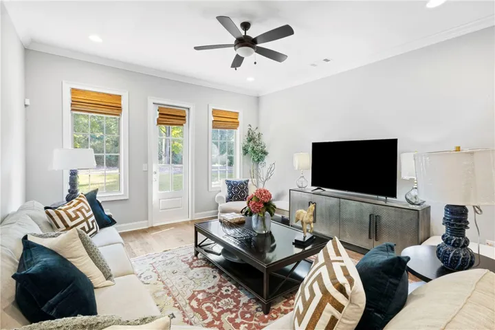 Rich hardwood flooring complements the tall windows and elegant crown molding in this inviting space.