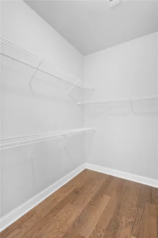 Rich hardwood flooring pairs beautifully with crisp white walls and convenient wire shelving.