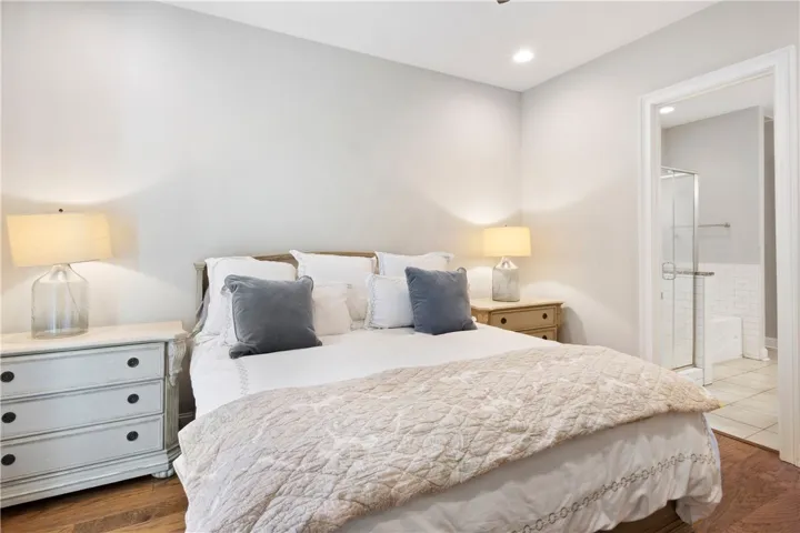 Rich hardwood flooring anchors this serene bedroom complete with a convenient private ensuite bathroom.