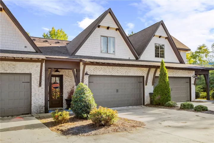 Striking architectural gables and a textured brick exterior define this multi-bay garage facade.