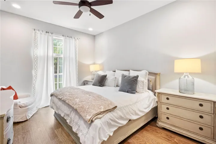 Rich hardwood flooring and recessed lighting set a warm, welcoming tone in this inviting bedroom.