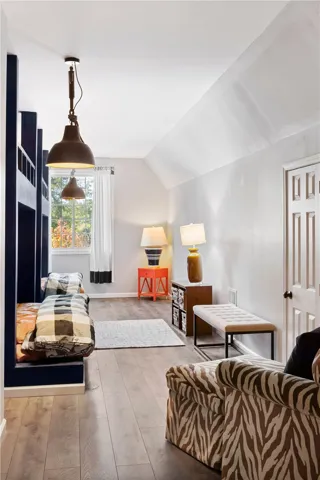 A sloped ceiling and warm wood-look flooring accent this versatile secondary bedroom space.