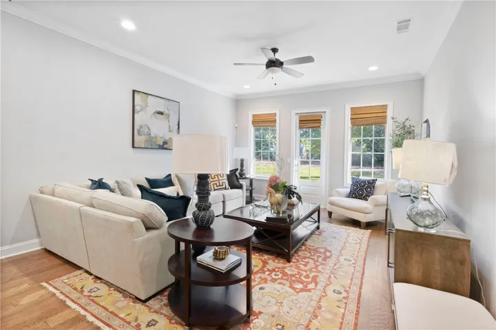Rich wood flooring and classic crown molding elevate this welcoming living space.