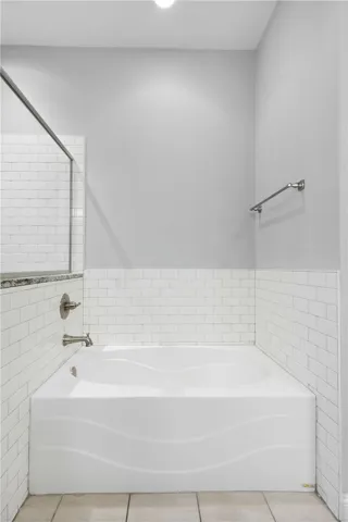 A deep soaking tub is framed by classic subway tile surrounds.