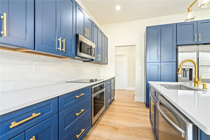 Rich blue cabinetry and warm wood flooring frame this beautifully appointed culinary space.