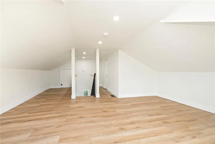 Angled ceilings and clean wood-plank flooring define this versatile top-level bonus space.