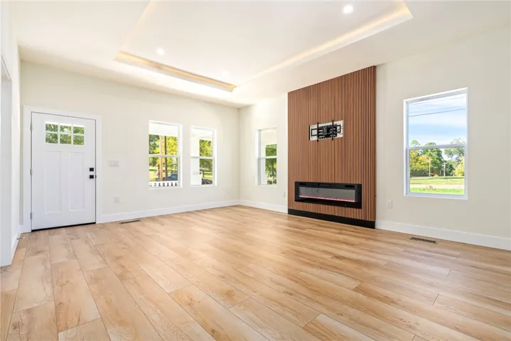 Rich wood floors and a contemporary linear fireplace define this inviting living space.