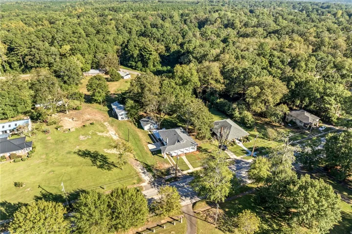 An aerial perspective showcases the home nestled within a peaceful, wooded residential neighborhood.