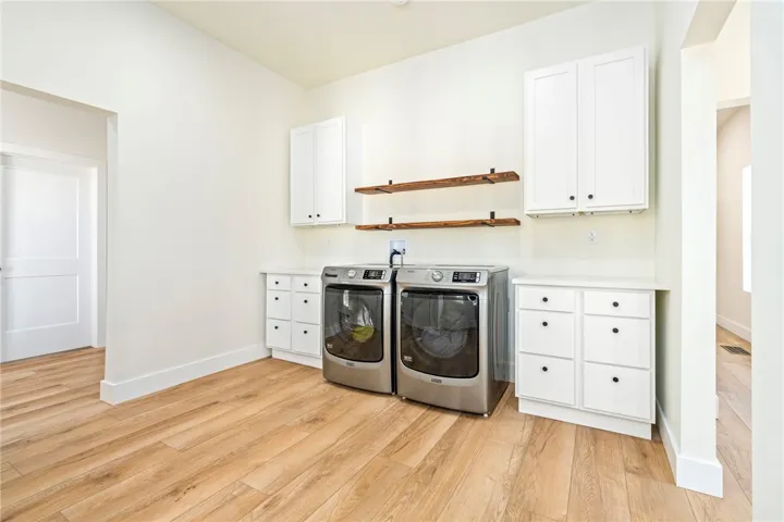 Smooth wood floors and crisp white cabinetry define this functional utility space.