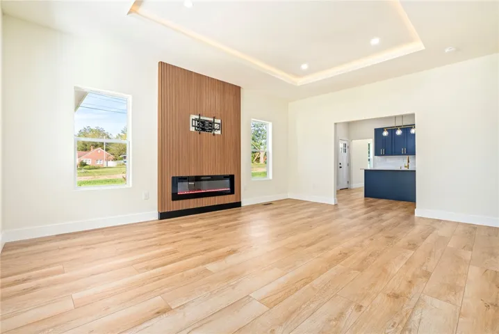 An integrated fireplace accents this light-filled room with clean lines and warm wood floors.