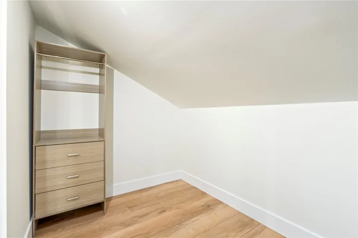 Slanted ceilings and warm wood floors define this cozy built-in closet space.