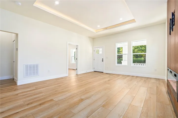 Warm wood flooring and an elegant tray ceiling define this open, airy living space.