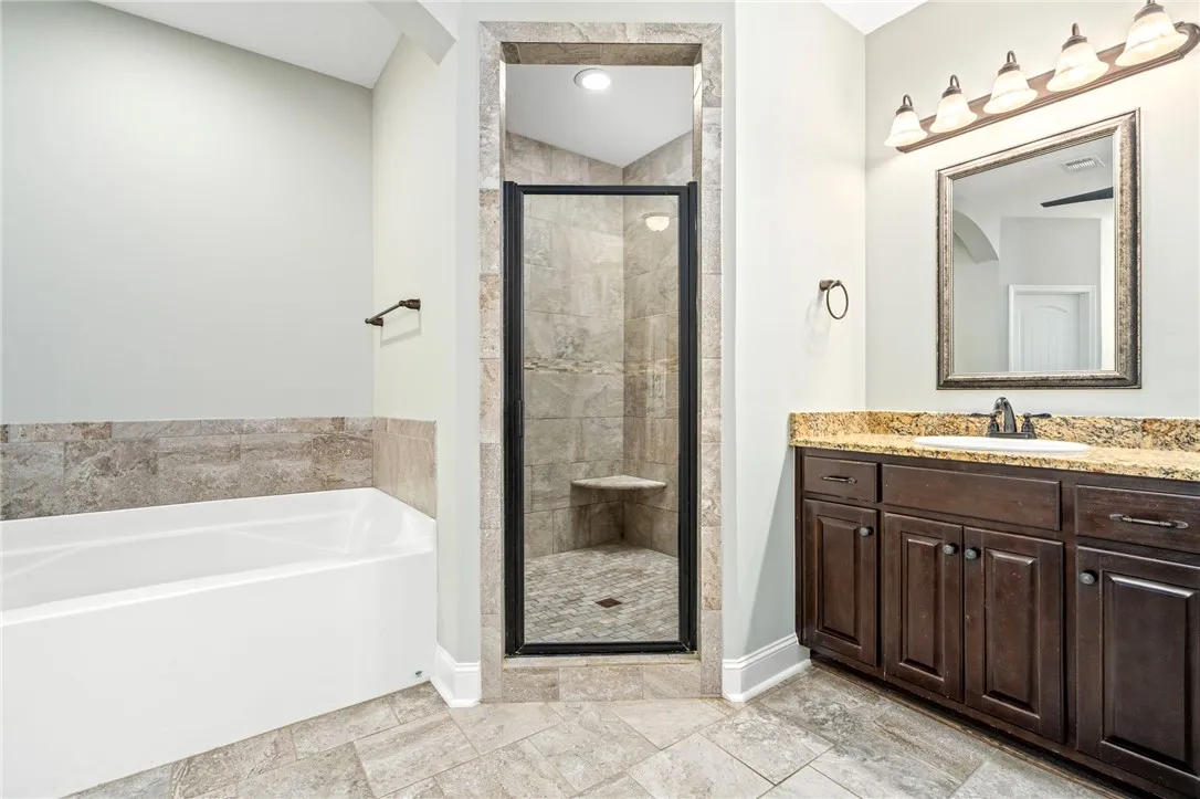 An inviting soaking tub and a tiled walk-in shower elevate this functional bathroom space.