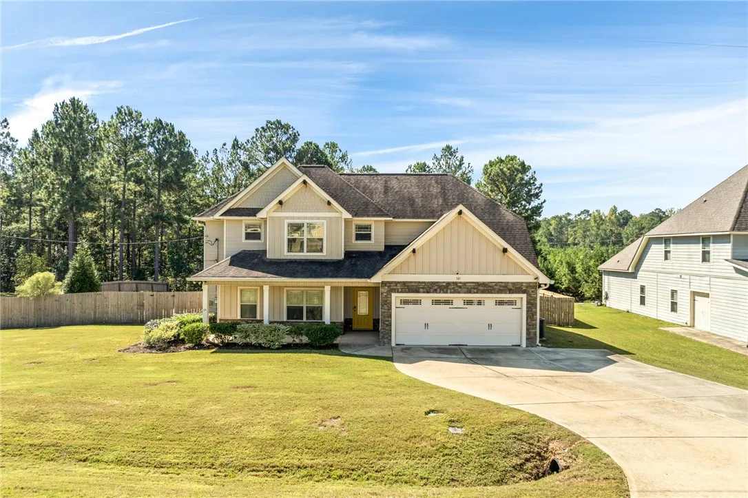 A classic two-story exterior features a paved driveway, integrated garage, and a manicured lawn.