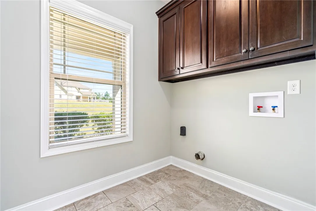 Rich wood cabinetry and classic tile flooring define this functional utility space.