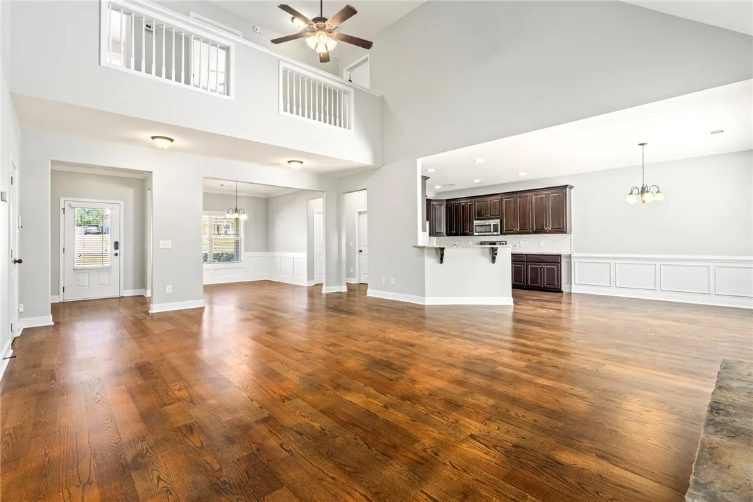 Gleaming hardwood floors and a soaring vaulted ceiling define this airy open-concept living space.