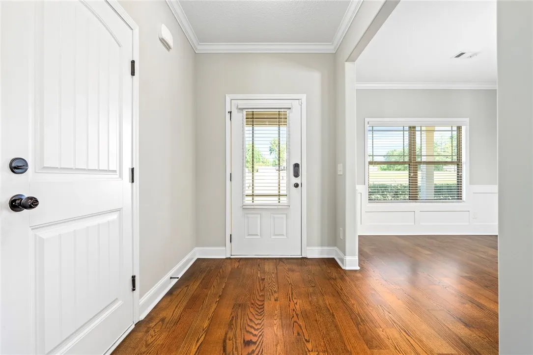 Rich hardwood floors and classic crown molding welcome guests into this airy entryway.