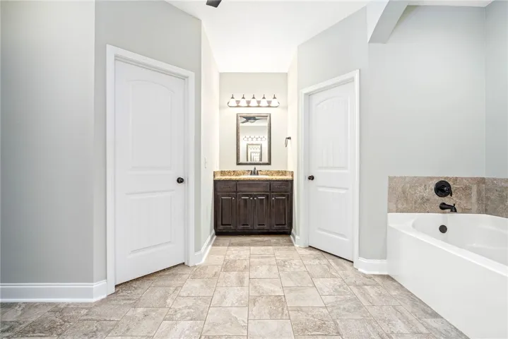 Tiled flooring and a built-in soaking tub anchor this spacious washroom layout.