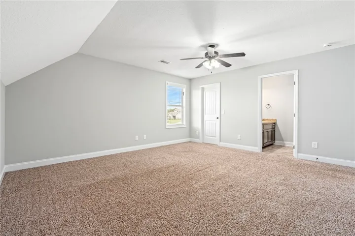 Plush carpeting and vaulted ceilings define this peaceful, neutral-toned upper-level bedroom suite.