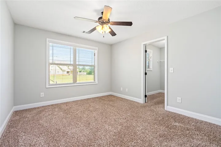 Plush carpeting and generous natural light define this comfortable secondary bedroom.