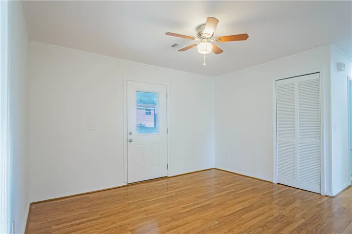 Warm hardwood flooring anchors this versatile space featuring a glass-insert exterior door.