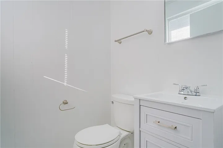 Clean lines and classic wood-paneled walls define this efficient half bathroom setup.