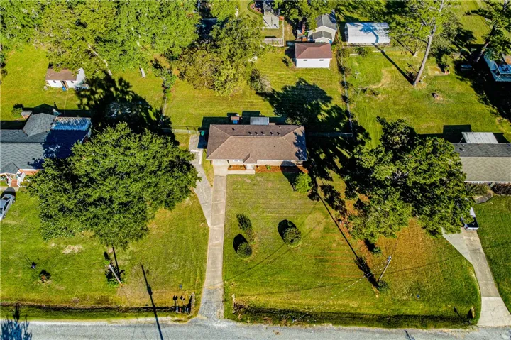 An overhead perspective reveals a classic suburban lot surrounded by mature trees.