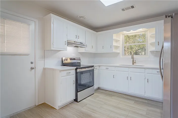Crisp white cabinetry paired with modern appliances creates a functional and inviting workspace.