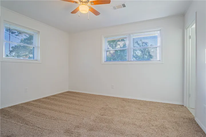 Soft plush carpeting pairs with natural light in this inviting bedroom space.