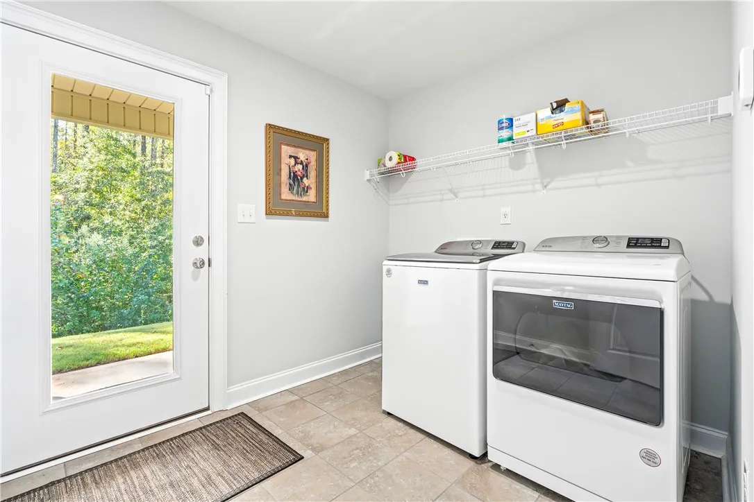 Tiled flooring and a glass exterior door define this functional utility space.