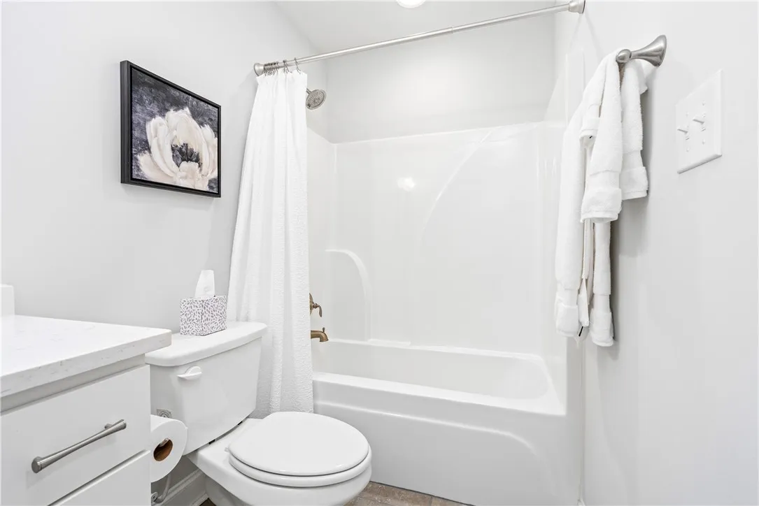 An inviting bathroom features a sleek tub and shower combination with clean white finishes.