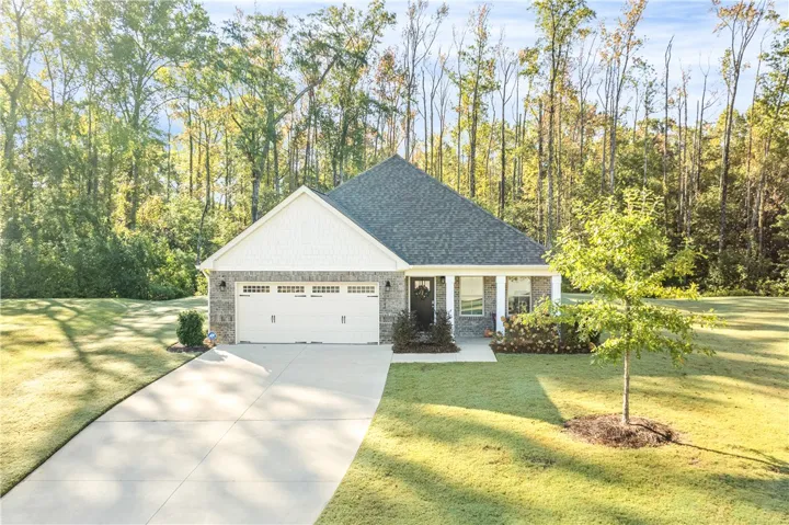 At the back of a short cul-de-sac, mature trees frame this charming brick home, featuring a double garage and covered front porch.
