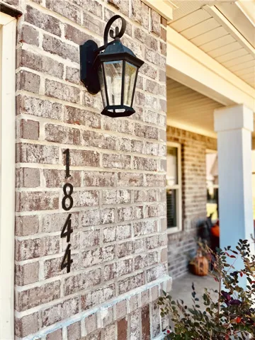 A classic brick exterior meets a welcoming covered porch entry.