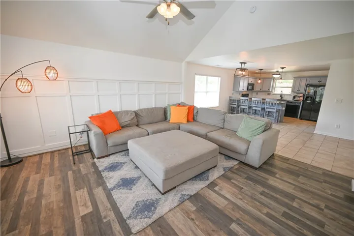 Gleaming wood-look floors complement the detailed wall paneling and airy vaulted ceilings.