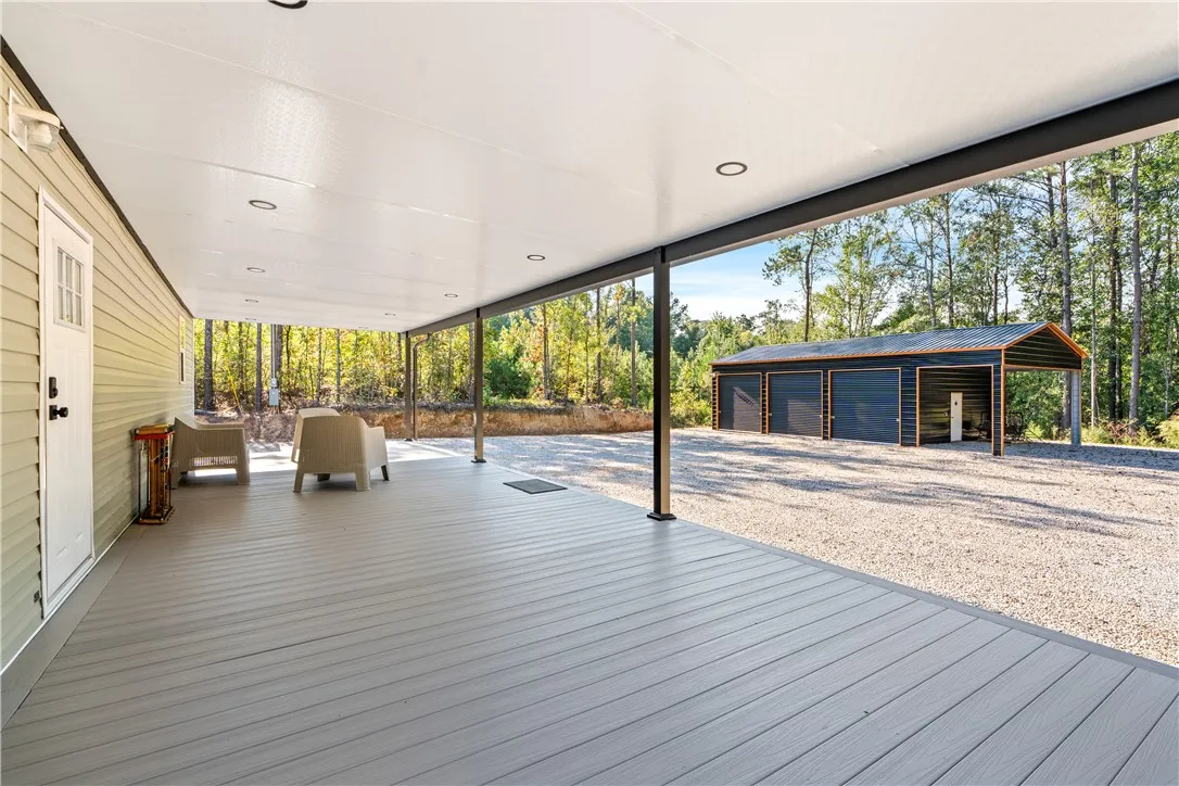 A sheltered composite deck offers a smooth transition to the gravel drive and detached garage.