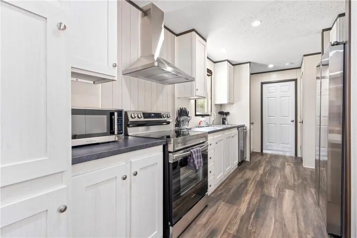 Rich wood-look flooring contrasts beautifully with crisp cabinetry in this thoughtfully arranged kitchen layout.