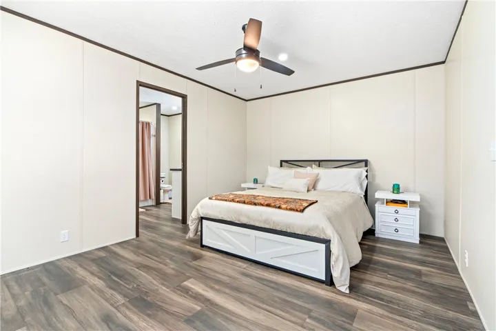 Gleaming wood-look floors anchor this bedroom, offering seamless access to an adjacent private bath.