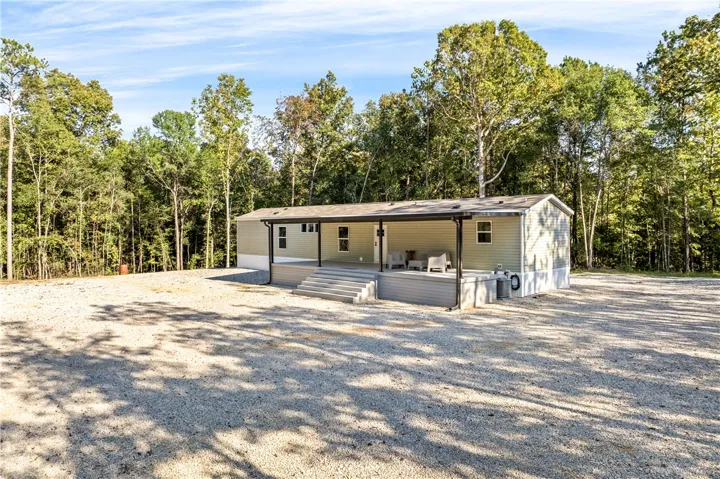 A spacious covered front porch frames the entry of this secluded home enveloped by mature trees.